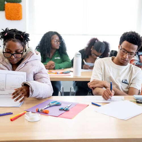 Students work at rows of tables on projects.
